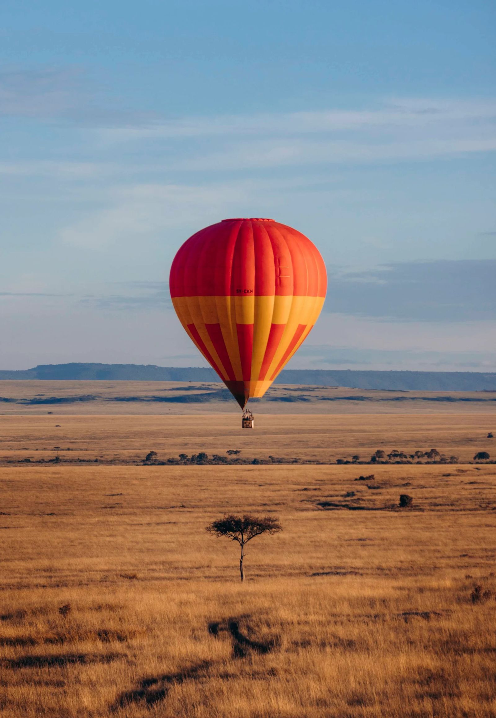 Hot air balloon floating over the Masai Mara plains in Kenya